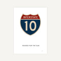 Interstate 10 road sign with text 'Headed for the Sun' on a white background