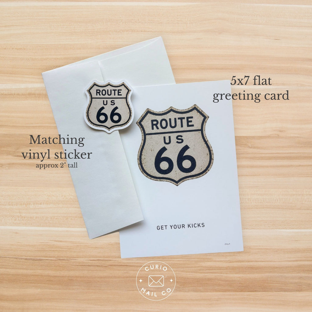 Route 66-themed greeting card and vinyl sticker on a wooden surface with Curio Mail Co branding.