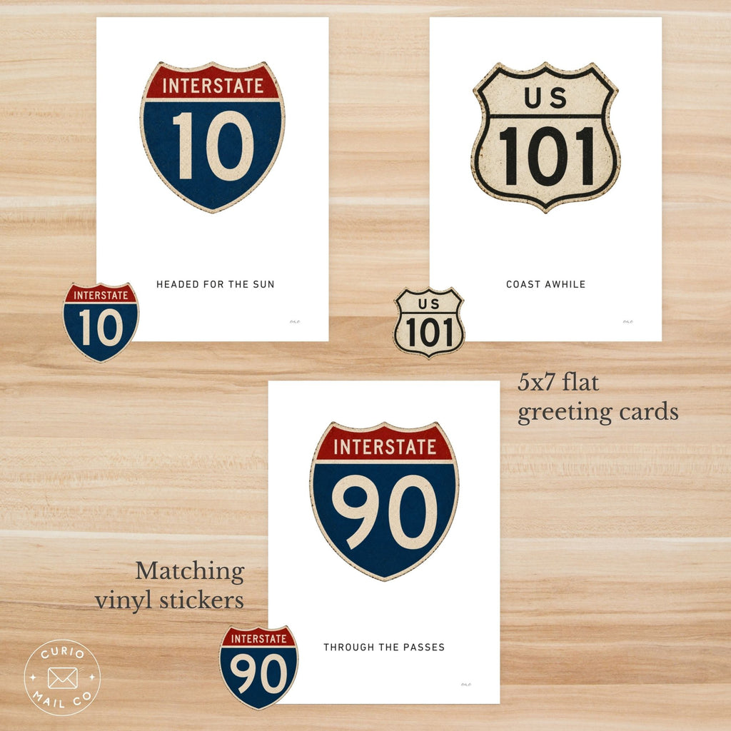 Greeting cards with highway route symbols on a wooden surface