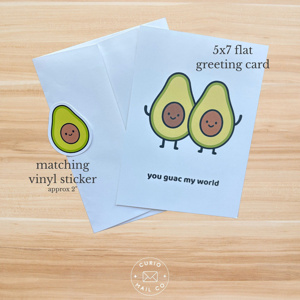 Two greeting cards with avocado illustrations on a wooden surface, featuring text and 'Curio & Co.' branding.