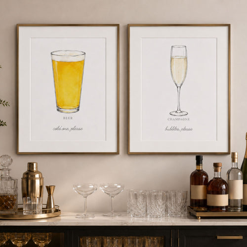 Two framed wall art prints hang above a bar counter. The left print shows a pint of beer with the text 'BEER cat o' nine, please' beneath it.