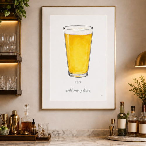A framed art print featuring a pint of beer on a white background, hung on a warm beige wall in a styled bar or kitchen setting with bottles, glasses, and a lamp.