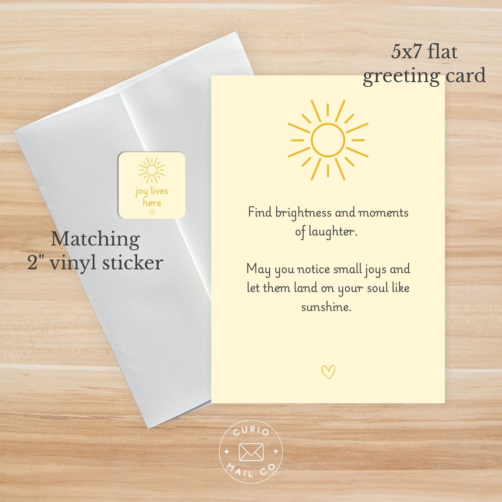 5x7 flat greeting card with matching 2" vinyl sticker on a wooden surface, featuring a sun design and text.