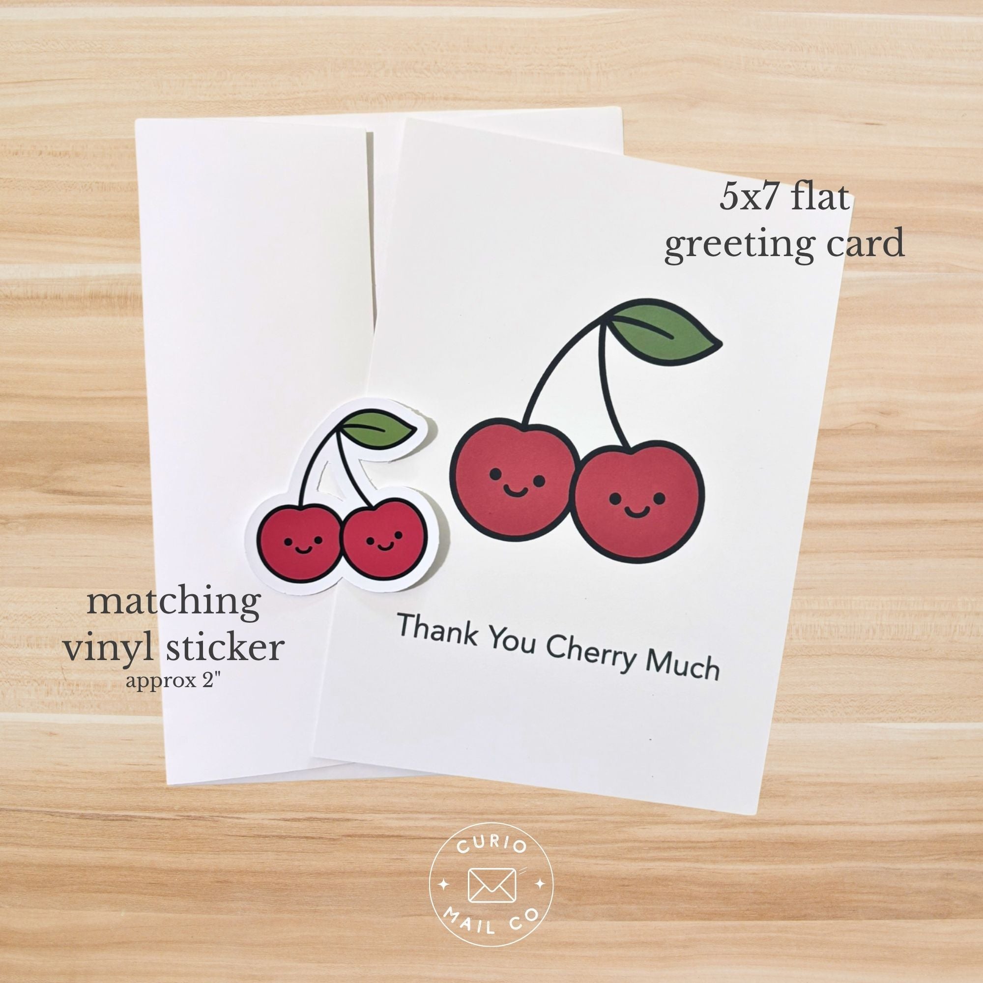 5x7 flat greeting card with cherry design on a wooden surface, featuring 'Curio Mail Co' branding.