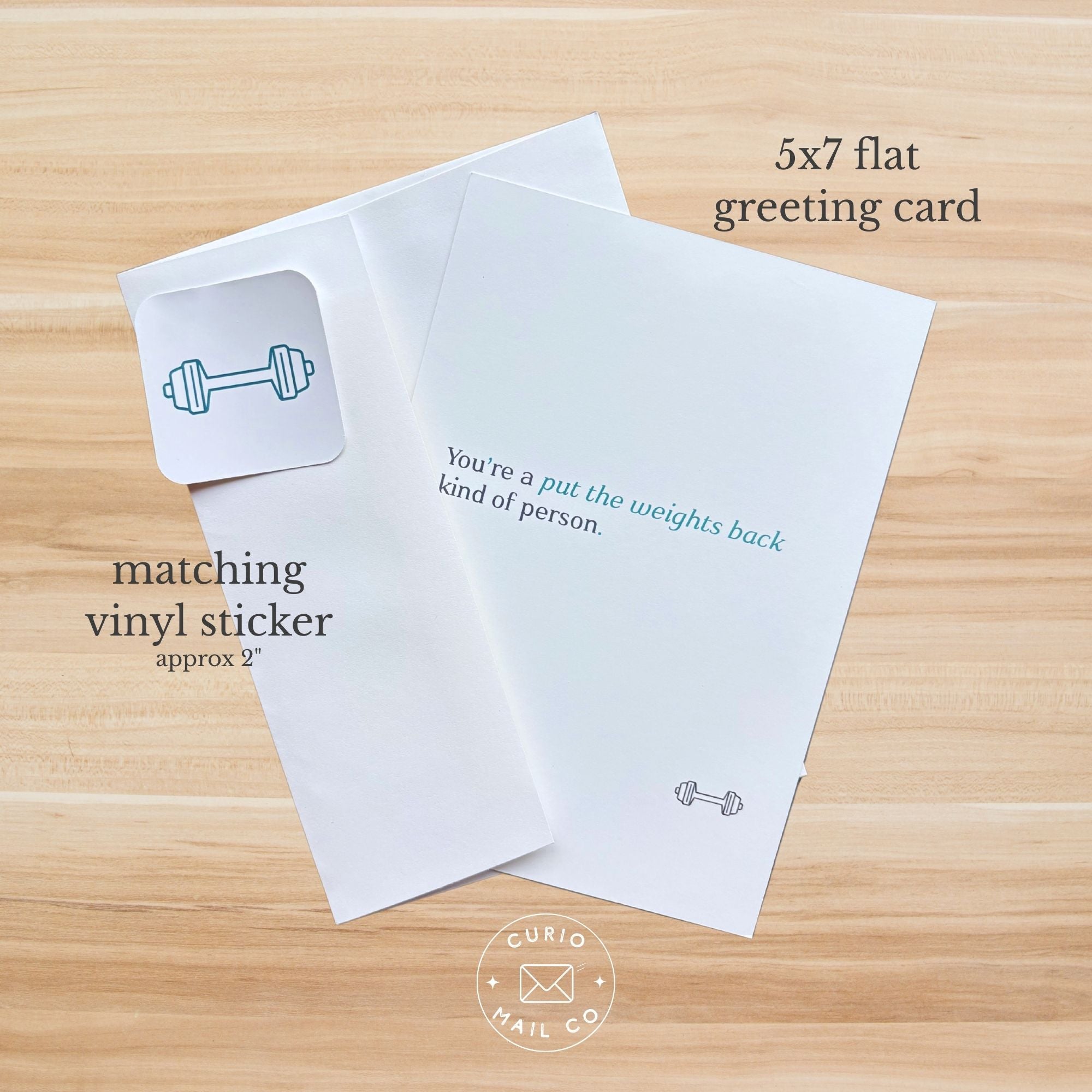 5x7 flat greeting card with matching vinyl sticker on a wooden surface, featuring text and a barbell icon.