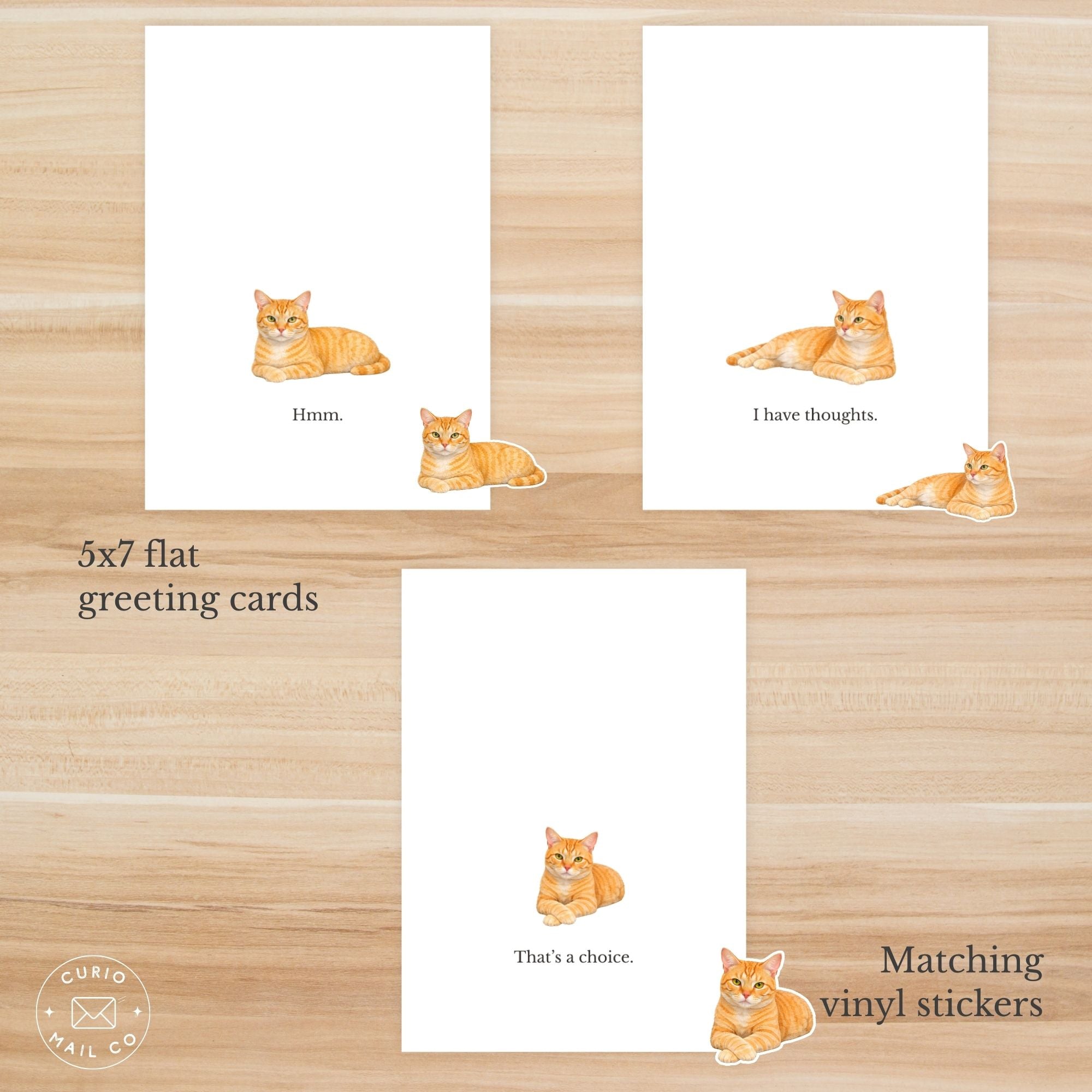 Set of 5x7 flat greeting cards with cat illustrations on a wooden surface, accompanied by matching vinyl stickers.