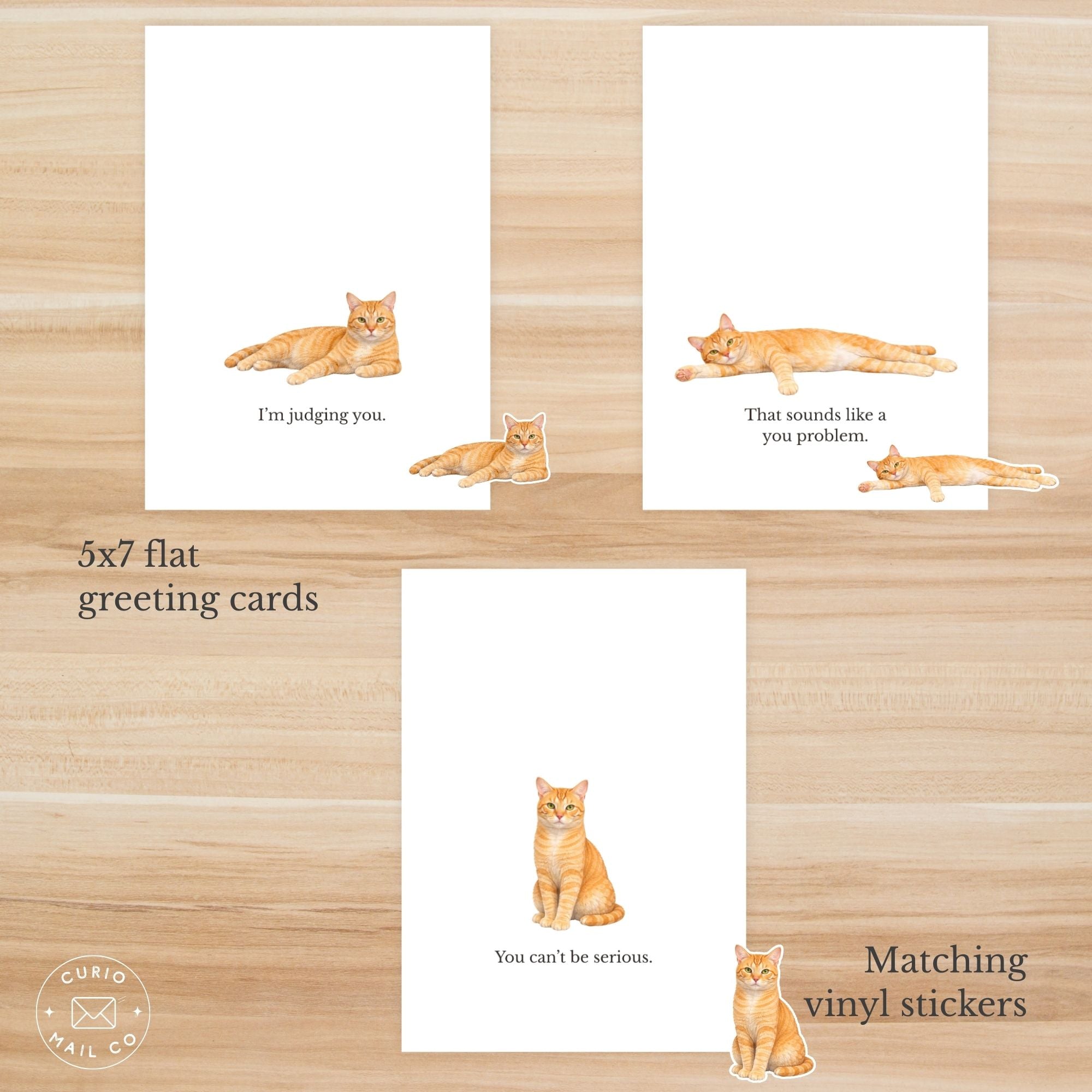 Set of 5x7 flat greeting cards with cat illustrations and matching vinyl stickers on a wooden surface.