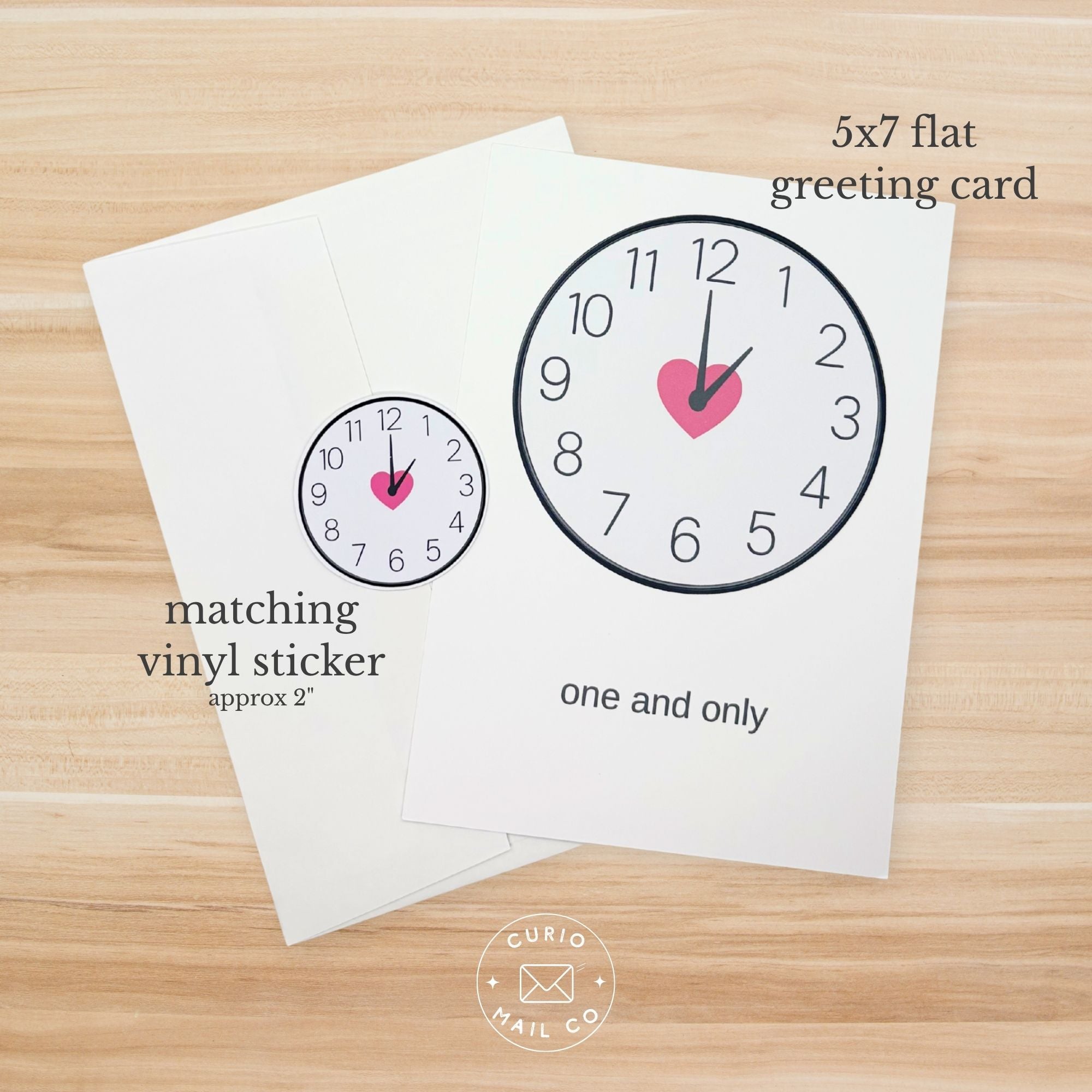 5x7 flat greeting card with clock design and matching vinyl sticker on a wooden surface.