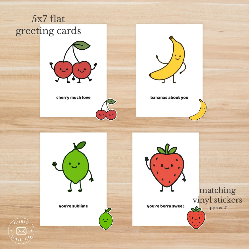 Four 5x7 flat greeting cards with fruit illustrations and matching vinyl stickers on a wooden surface.