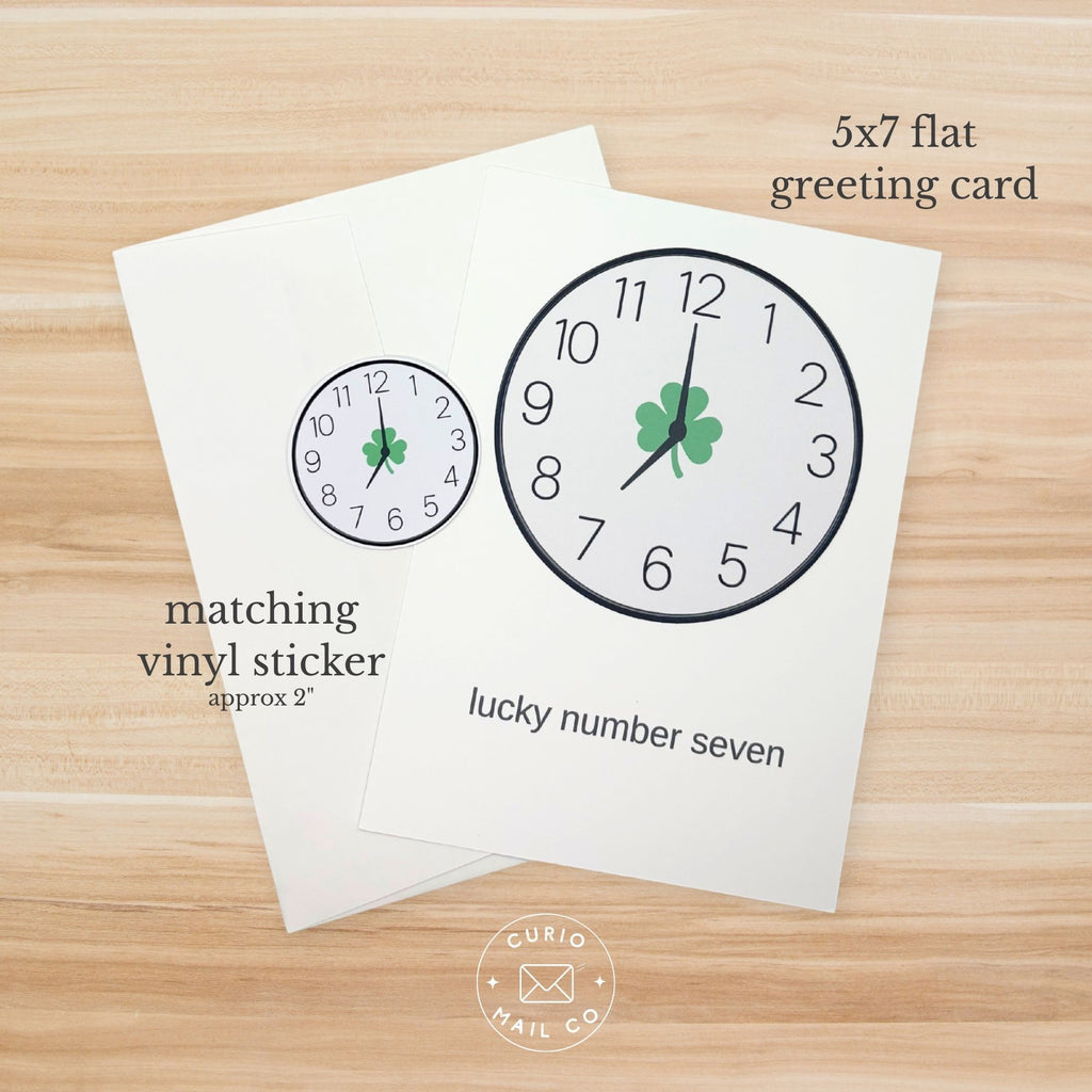 5x7 flat greeting card with clock design and matching vinyl sticker on a wooden surface.