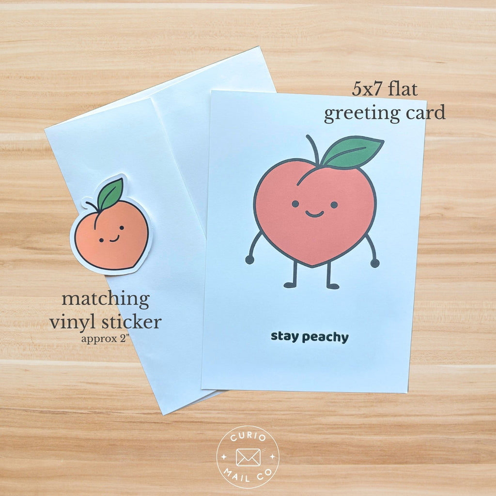 5x7 flat greeting card with a peach illustration and matching vinyl sticker on a wooden surface.