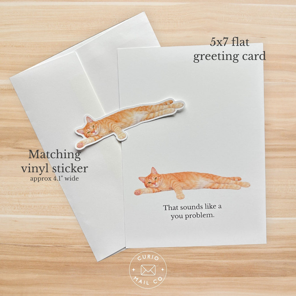 5x7 flat greeting card with matching vinyl sticker featuring a cat on a wooden surface, Curio Mail Co. branding visible.