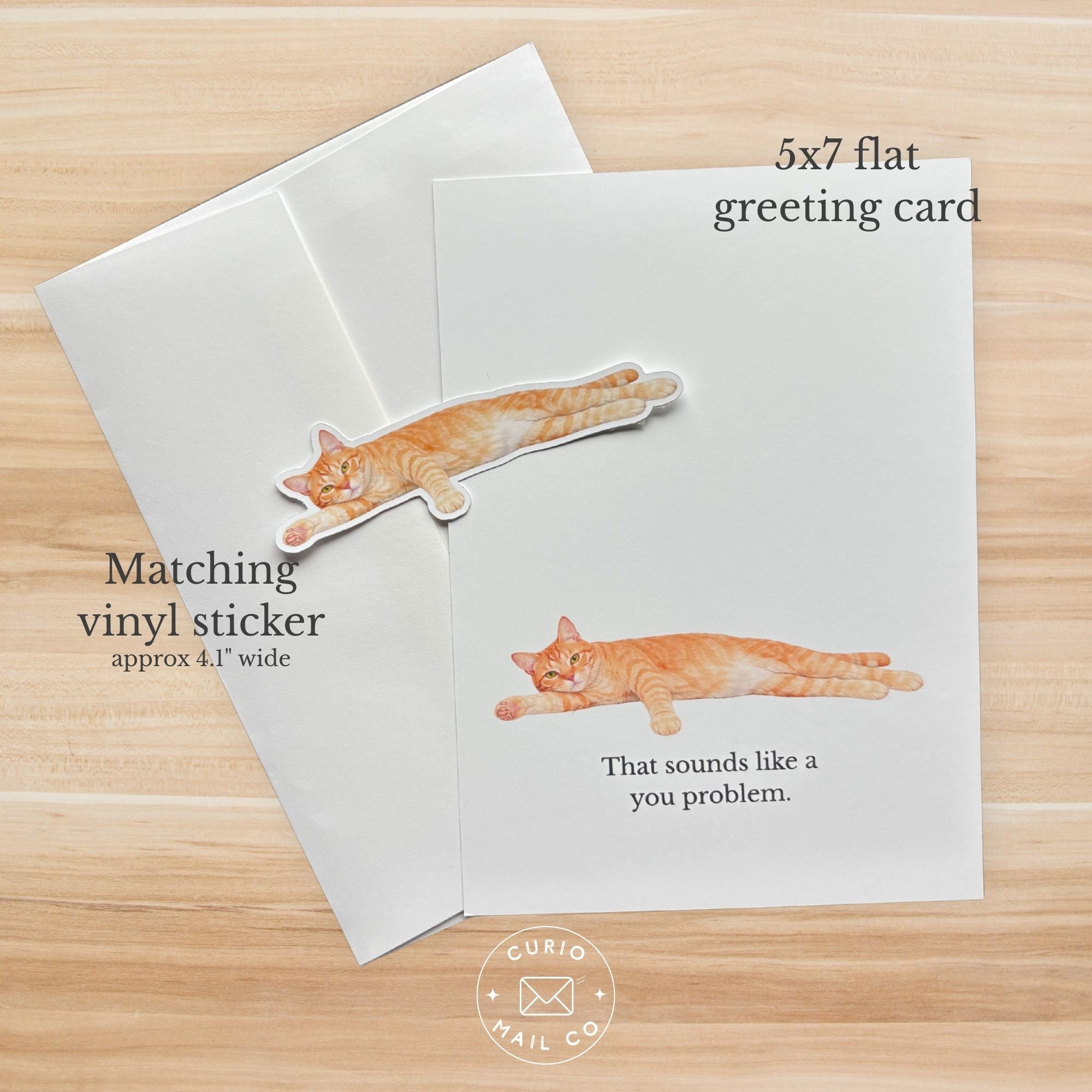 5x7 flat greeting card with matching vinyl sticker featuring a cat on a wooden surface, Curio Mail Co. branding visible.